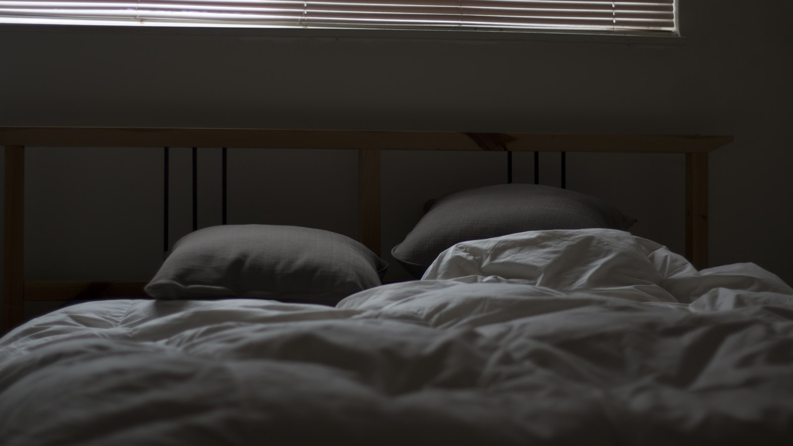 Empty bed with white linens — collagen work at night