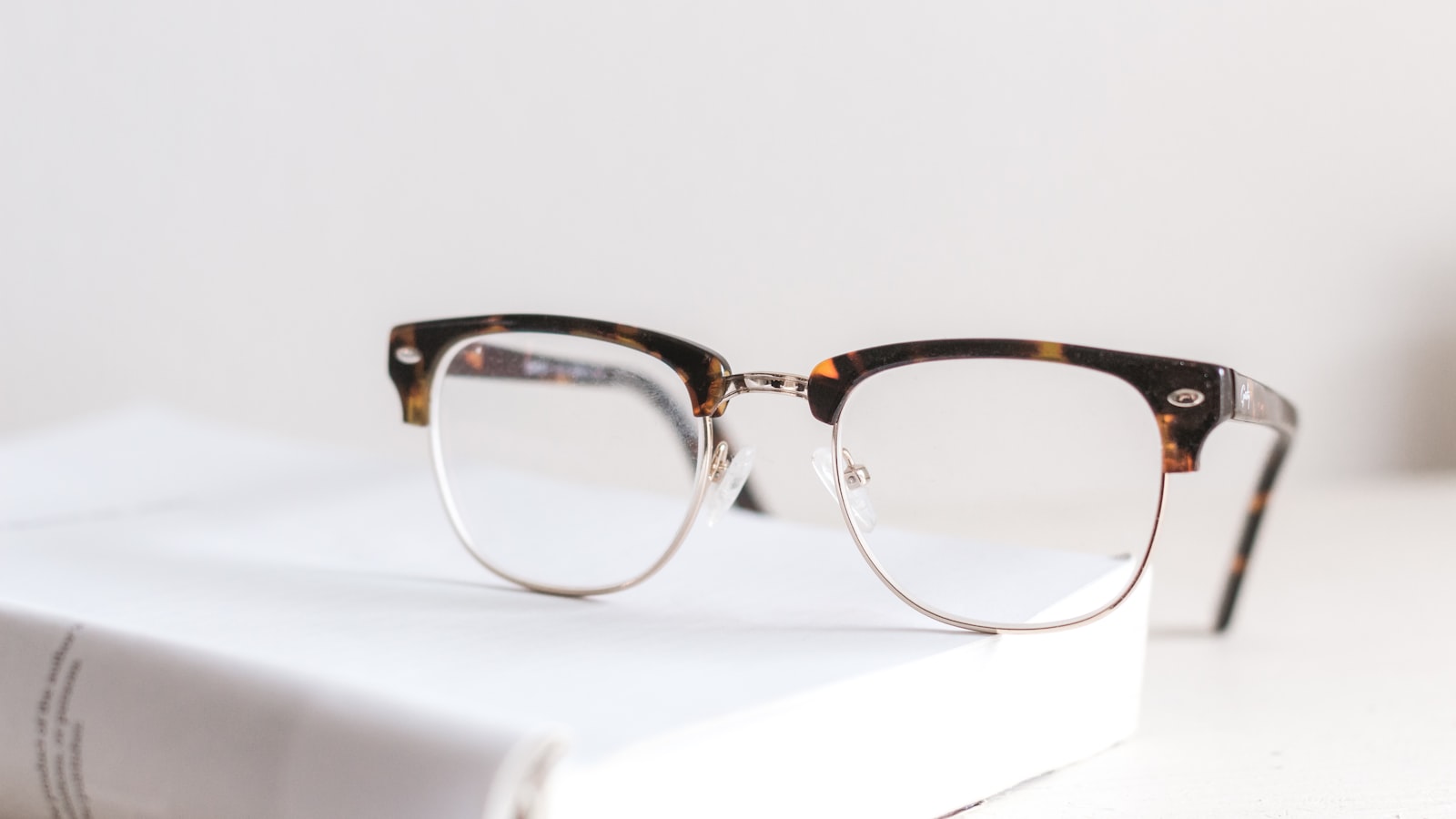 Clear eyeglasses resting on an open book — skin in your forties